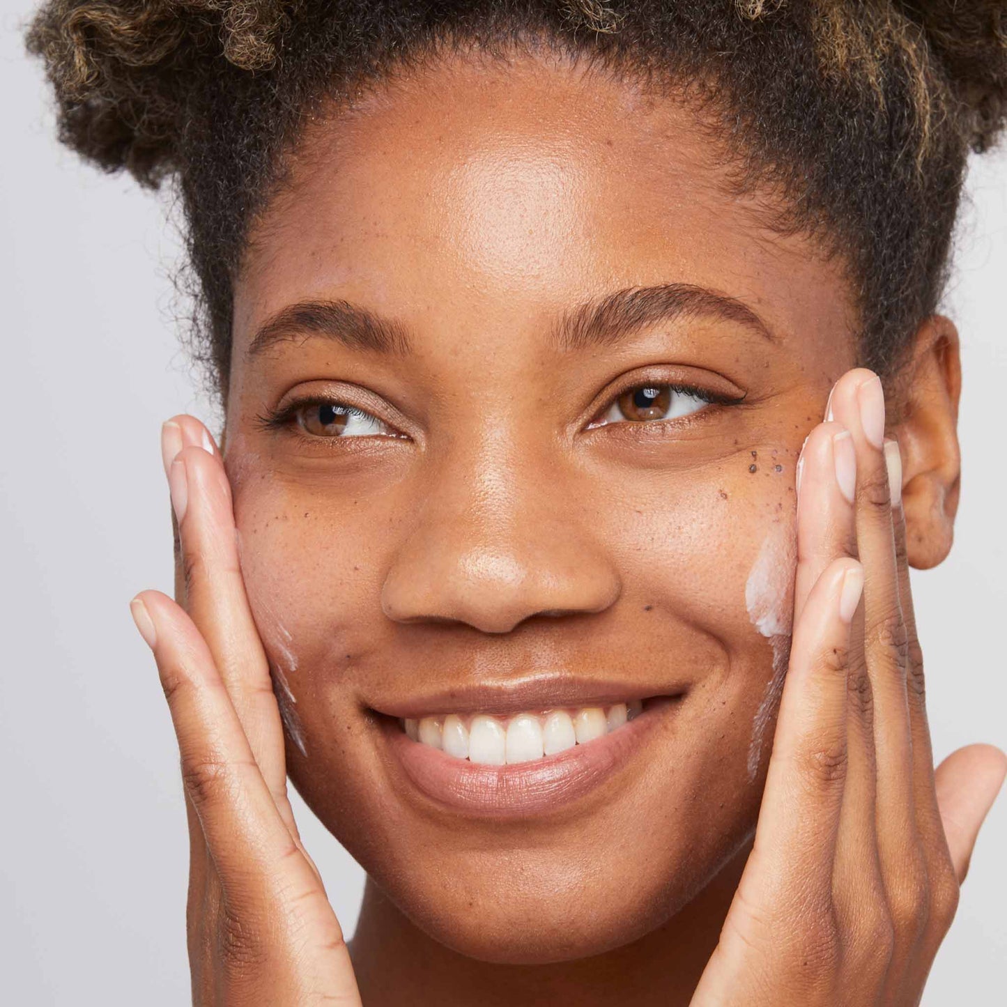 woman applying skin smoothing cream to face 