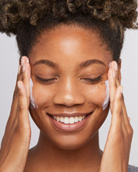 woman applying spf onto face